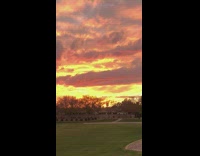 Guy standing outside watches sunset orange sky