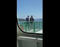 Black shorts guy poses green railing boat 