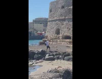 Woman yellow dress sit beside castle walls