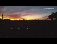 Drone flies straight up towards sunset sky 
