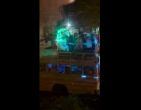 Party bus rolling down the street with people sitting on top of bus