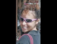 Girl wearing pink sunglasses turns and smiles 