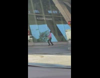 Guy holding brown paper bag dances before walking away