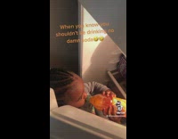 Little girl drinking orange soda from bottle in fridge 