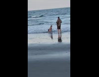 Girl black bikini kneel splash water beach