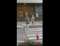 Woman in orange outfit poses in the middle of the street