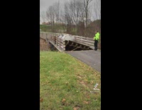 Emergency response team to tanker truck stuck in collapsed bridge