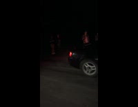 Guy in black car run exhaust at night
