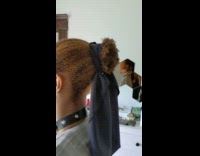 Guy brown curly hair tied with scarf