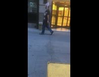 Man with metal skeleton headpiece walks down sidewalk