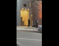 Woman in black dress and leather jacket models on the alley