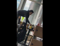 Guy stands chair restaurant food black sweater