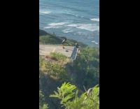 Girl sit raise arm helipad corner mountain