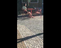 Girl takes photos alone red table outside 