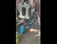Guy smashes beer cans with cement block 