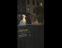 woman looking through trash in container 