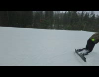 Guy wearing green gloves falls while snowboarding