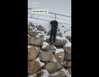 Guy on rocks almost slips and falls