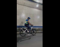 Guy bikes with tons of boxes attached 