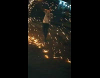 Guy swings firework in circle on street
