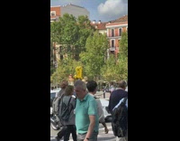 Woman in shiny gold dress celebrates with number 31 balloons in the street