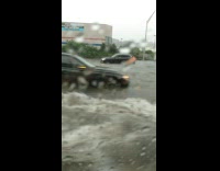 Driver drives past cars stuck in the road from flood 