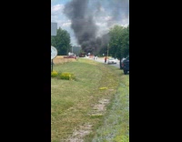 Crashed small aircraft burn on road ground