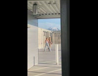 Two female dancers perform for video near parking 