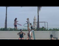 Two women spin hula hoop pool windy