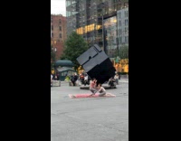 Two women interpretative dance beside Cube statue