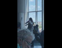 Two large women tiktok dance airport lobby