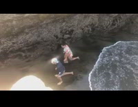 two people run up cliff beach