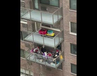 People on balcony shake maracas play drums 