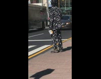 Black suit guy waits crosswalk white can 