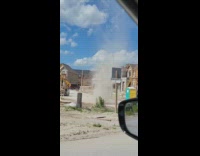 Dust devil on street near construction materials
