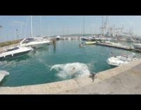 Black shorts guy jumps into blue water