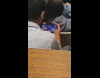 Man plays mobile game while inside class