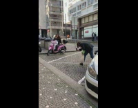 Woman in white pants sits on a pink scooter
