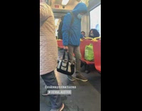 Blue jacket guy holds bag dog inside