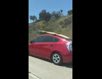Red prius surfboard on roof