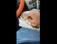 Guy in car getting ready to eat his burger