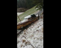 Wood boat falls off trailer onto snow 