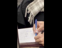 Woman sketches grandma with two pen inside train