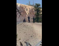 Guy squats edge of mountain tree branch