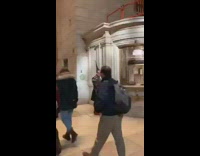 Woman wearing a heavy leather chained jacket with gelled pointy hair at a train station