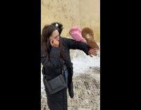 Girl with three colorful birds on arm scared