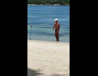 Man films himself with tripod at beach