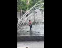 Woman walk and bath at water fountain