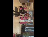 Guys in pink gowns dance and perform in building