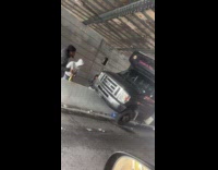 Men make fun of bus stuck on divider